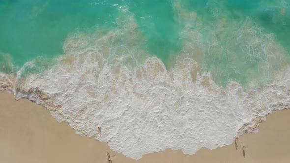 Drone Footage of People at White Sand Beach with Azure Water Foaming Ocean Waves alt
