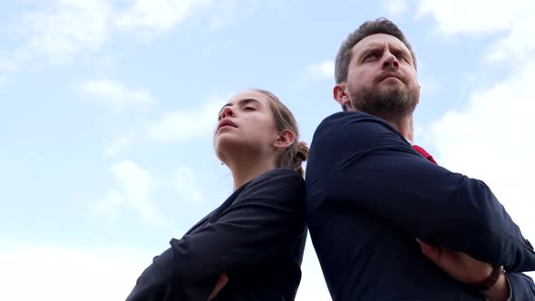 Confident Business Couple of Serious Guy and Girl Stand Keeping Arms Crossed on Sky Confidence alt