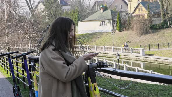 Woman use cell phone to rent scooter