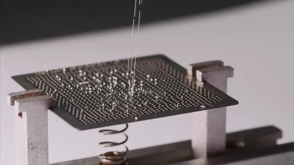 Tiny Silver Metal Balls are Falling on the Chip Side View alt