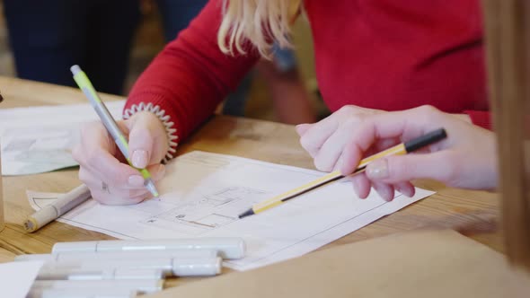 Young Female Architect Smiling and Drawing Building Plan