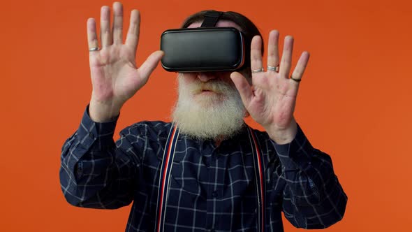 Senior Stylish Grayhaired Man Using Headset Helmet App to Play Simulation Virtual Reality VR Game alt