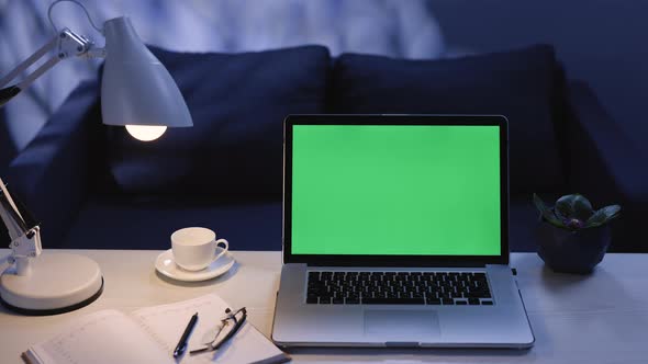 Modern Chroma Key Green Screen Laptop Computer Set Up for Work on Desk at Nigh