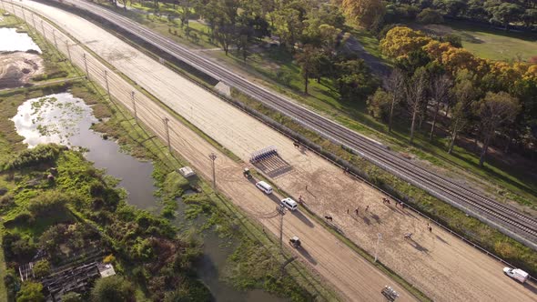 Jockeys and race horses prepare for race, orbit aerial view alt