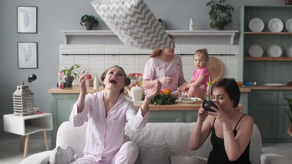 Three Women and Kid Sitting Together on Kitchen in Morning.