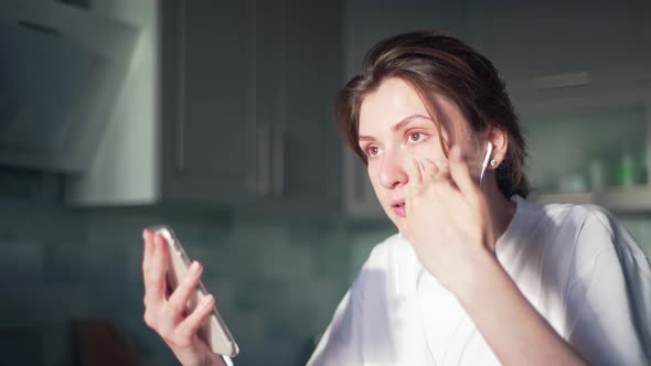 The Woman Communicates Via Webcam and Headphones on Her Phone. Online Work, Freelance. Working alt