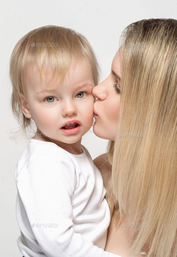 Mother with baby portrait child Woman with blonde hair and daughter kiss