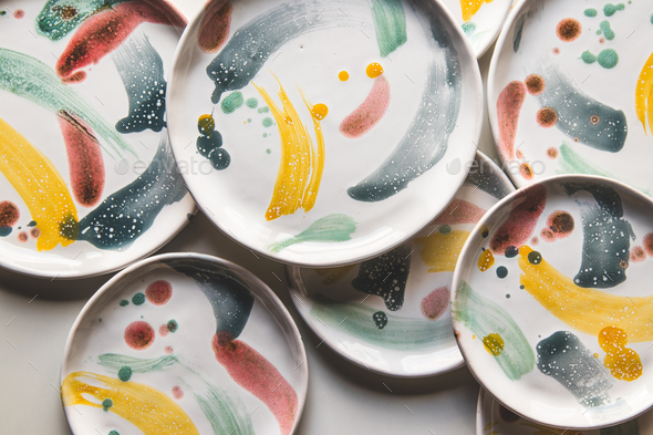 Hand-painted ceramic plates. Collection of colorful ceramic on white