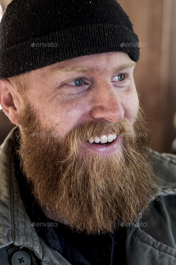 Portrait of smiling bearded man with light brown hair, wearing black ...