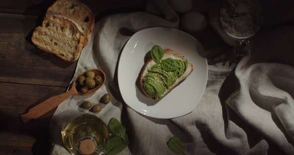 Appetizing sandwich with avocado and spinach, with olives and butter.