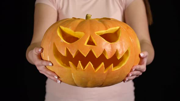 Woman Showing Jack O' Lantern Pumpkin for Halloween Celebration alt