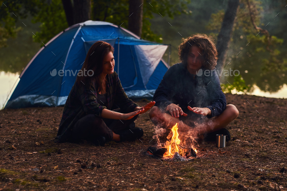 Young Hipster Couple Hiking In The Forest Warming Near A Campfire At Camp Stock Photo By Fxquadro