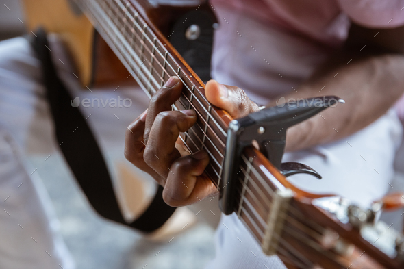 Close up of african-american musician playing guitar during online concert at home isolated and
