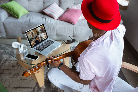 African-american musician playing guitar during concert at home isolated and quarantined, impressive