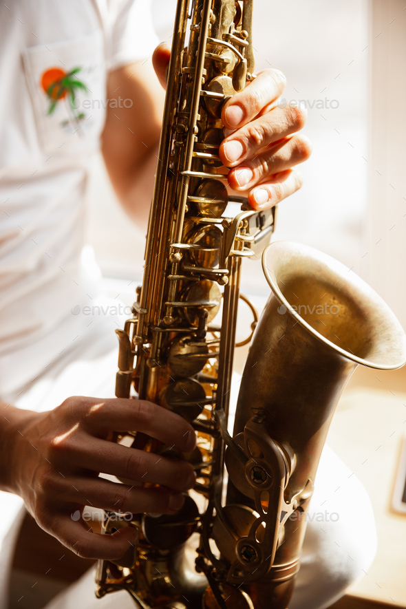 Close up of caucasian musician playing saxophone during concert at home isolated and quarantined