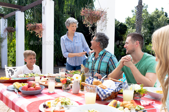 Caucasian family sitting at table during a family lunch in the garden