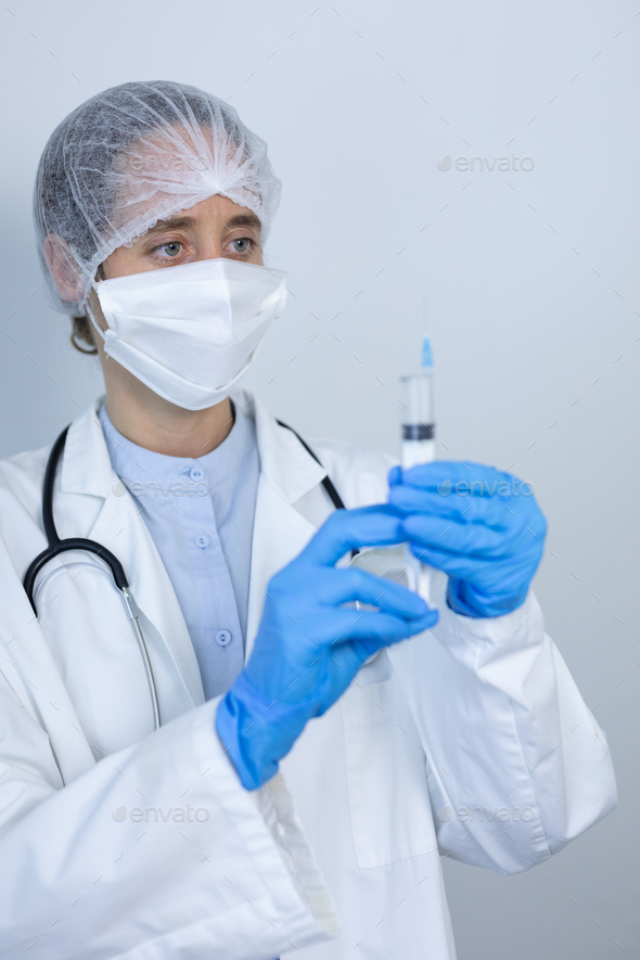 Healthcare worker holding a vaccine and face mask during coronavirus Covid19 pandemic