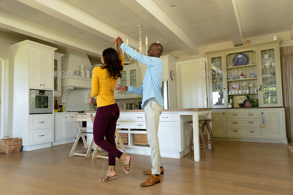 Happy couple dancing in their kitchen