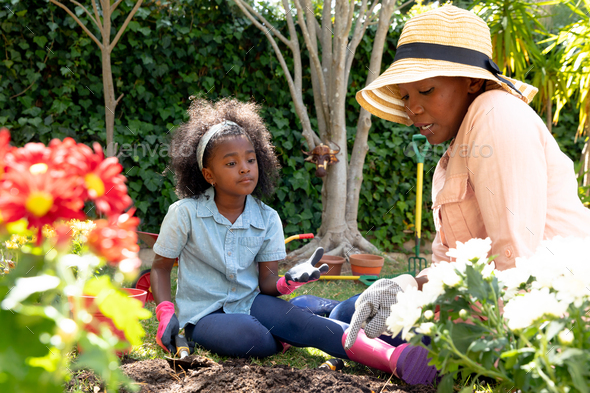 Happy Woman Planting Flowers At Her Backyard Stock Photo