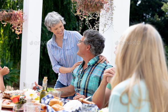 Caucasian family sitting at table during a family lunch in the garden