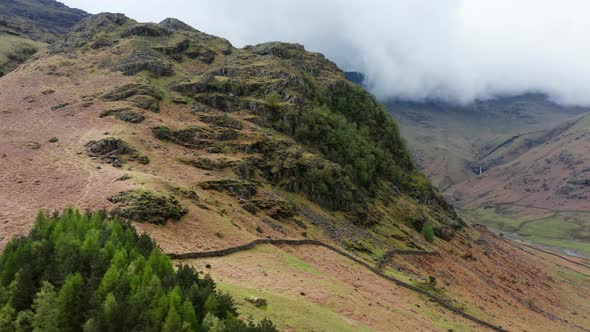 Aerial View Over Hills Towards Mountains