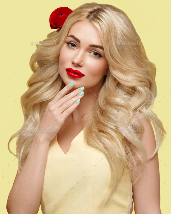 Beauty woman with long curly blonde hair flower hair manicured nails trendy colors orange and yellow