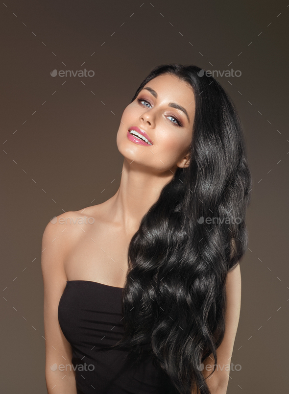 Woman with Black Long Hair and natural Make up over dark background