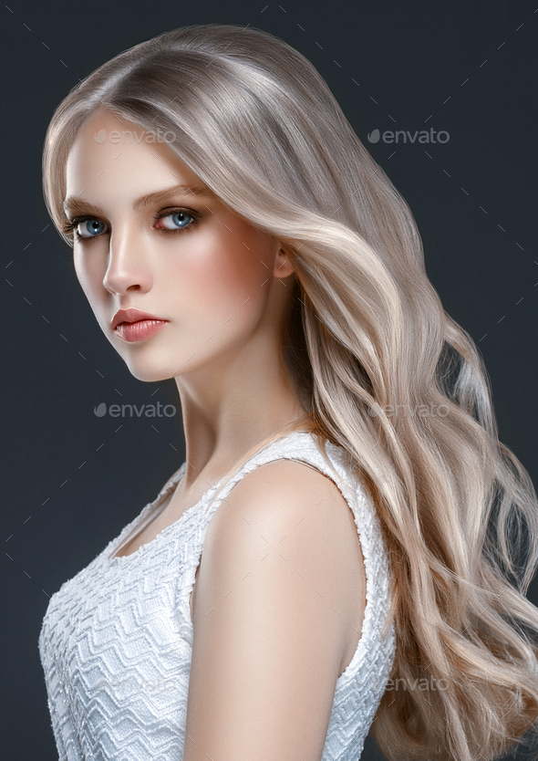 Adorable beautiful girl with long wavy hair. Blonde model with hairstyle  over black background Stock Photo by kiraliffe