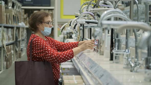 Senior Woman Buying Kitchen Faucet in a Store alt