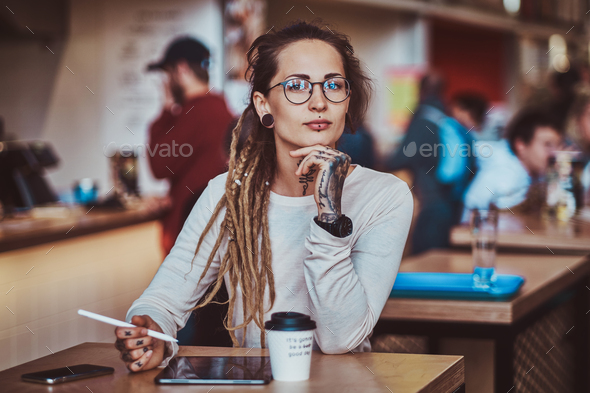 Portrait of beautiful tattoed girl with sketch pad Stock Photo by fxquadro