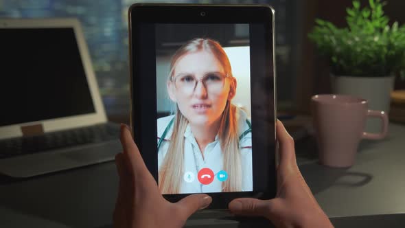 Tablet Screen with Blonde Female Doctor in Glasses Consulting the Patient Online