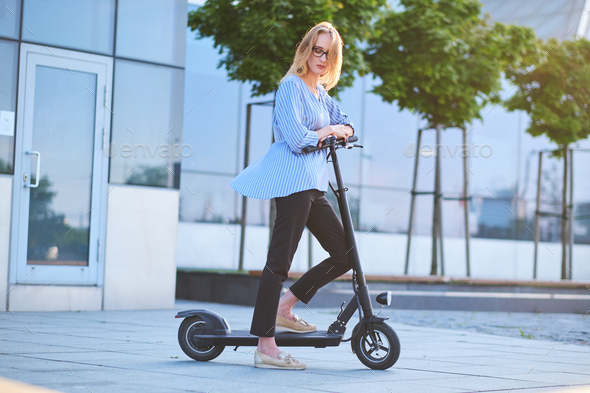 Young woman is enjoying riding on her new scooter