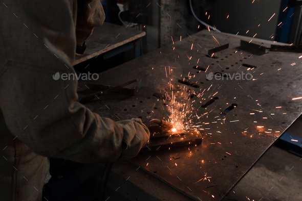 Cropped Image of Worker in Protection Mask Welding Metal at Factory