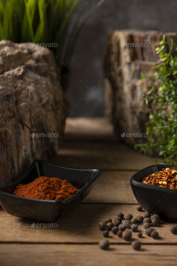 Two black small bowls with dry chillies and sweet paprika