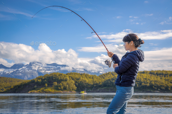 Woman fishing on Fishing rod spinning in Norway. Stock Photo by cookelma