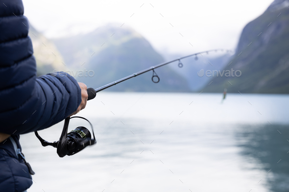 Woman fishing on Fishing rod spinning in Norway. - Stock Photo - Images