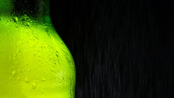 Half a Cold Green Bottle of Fresh and Refreshing Beer is Sprayed with Water