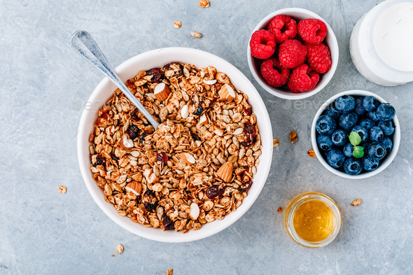 Granola cereals with fresh berries, almonds, milk and honey for ...