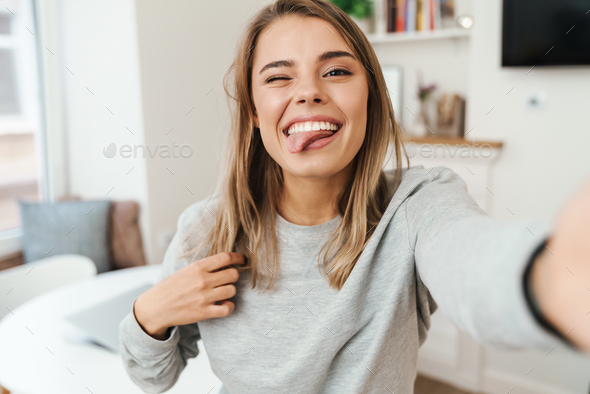 Photo Of Woman Sticking Out Her Tongue And Winking While Taking Selfie