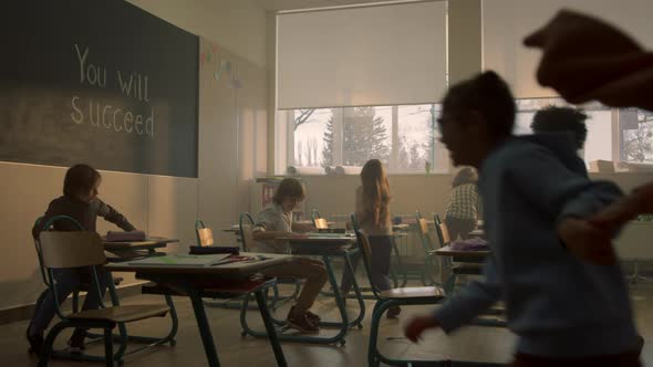 Positive Schoolchildren Running in Classroom After Break at Elementary School alt