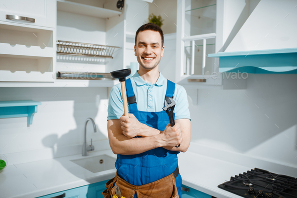 Cheerful male plumber holds wrench and plunger - Stock Photo - Images