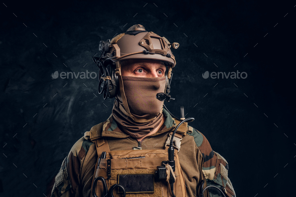 Close-up portrait. Private security service contractor in camouflage helmet with walkie-talkie.