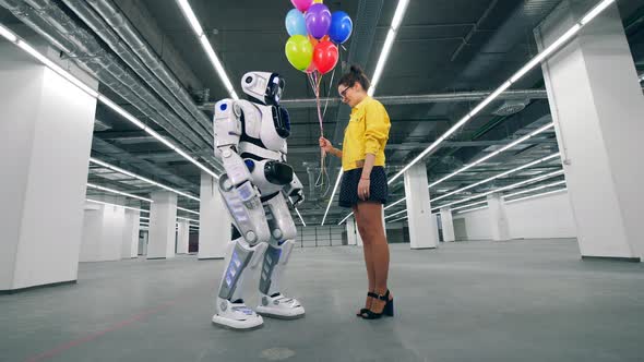 Human-like Robot and a Girl Are Holding Balloons Together alt