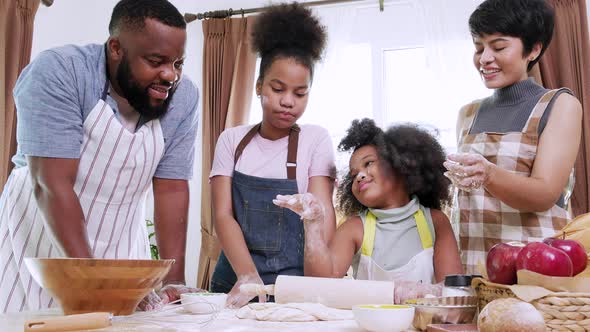 Two Kids and family enjoy preparing flour for cookies in the kitchen at home.
