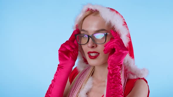Cute Young Woman in Santa Claus Costume and Glasses