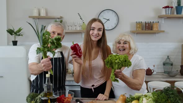 Girl with Mature Man and Woman Recommending Eating Raw Vegetable Food. Healthy Nutrition Diet alt