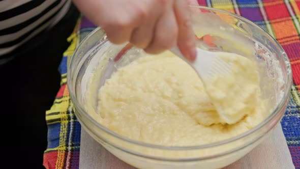 Senior Caucasian Woman Stirring Sweet Liquid Dough in the Bowl with White Plastic Spatula