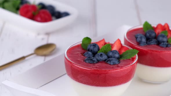 Fruit Jelly Dessert or Panna Cotta with Fresh Strawberries and Blueberries on White Background
