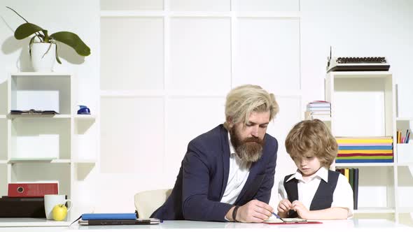 Businessman Father with His Son Drawing on Business Papers at Office alt