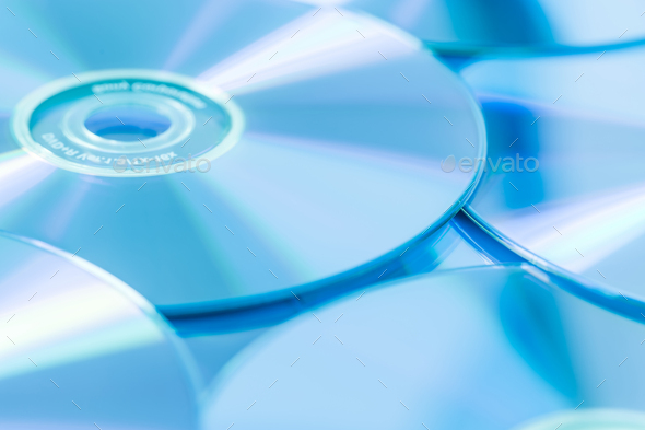 Stack of CD or DVD in blue tone as background. Soft focus.